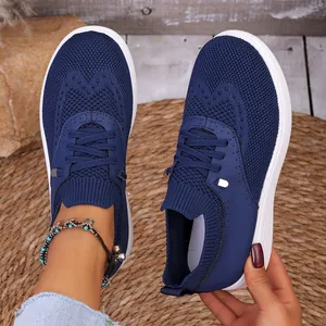 Detail van blauwe ademende flyknit instapsneakers met dikke witte zool voor dames