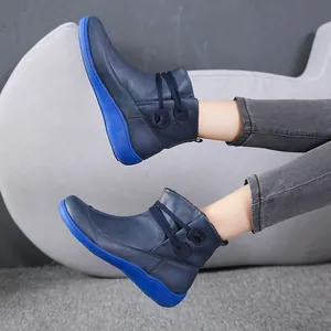 Close-up of navy blue British style work boots with bright blue thick platform sole