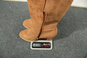 Misurazione del peso degli stivali alti in pelle scamosciata marrone con zip laterale