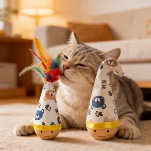 Due giocattoli conici per gatti con piume e motivi di orso in un ambiente domestico caldo