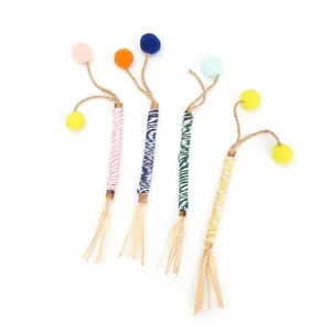 Detail view of natural Silvervine sticks for cats with colorful pom-poms and tassels.