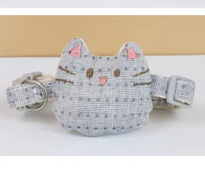 Detailed view of cat head shaped pet collar accessory with embroidered features