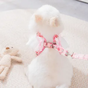 Set pettorina e guinzaglio per cani a quadretti rosa con ali d'angelo decorative.