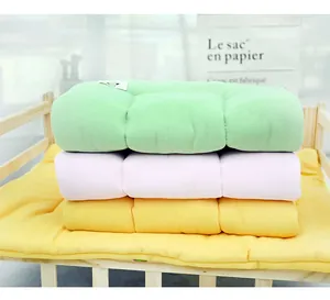 Detail view of stacked waffle texture macaron pet cushions in a wooden bed frame.