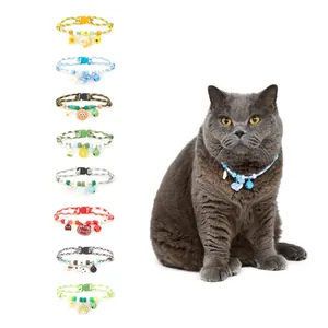 Various colorful cartoon pet collars with bells shown on a grey cat model in white background.