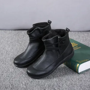 Detailed view of black women's leather ankle boots with warm faux fur lining and tie detail