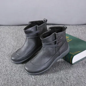 Close-up view of women's grey leather ankle boots featuring unique button strap details.