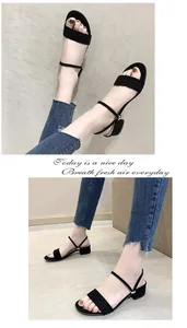 Detalle de sandalias negras de tacón bajo con diseño minimalista de una tira y soporte al tobillo.