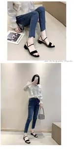 Elegante modelo asiática con sandalias negras de tacón bajo en un ambiente refinado.