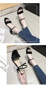 Detalle de cerca de sandalias negras minimalistas de tacón bajo con diseño de tira