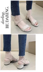 Detalle de elegantes sandalias beige con tacón de bloque bajo y diseño de tira