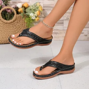 Detailansicht schwarzer Keilsandalen mit Retro-Nähten und weicher Sohle