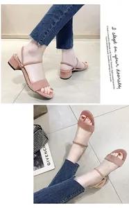 Primer plano de sandalias de gamuza rosa con tacón bajo y correa ajustable para doble uso