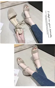 Detalle de sandalias beige con tacón de bloque y correa de tobillo versátil de dos vías