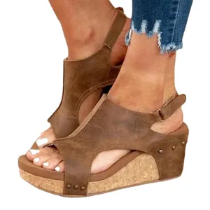 Elegantes sandalias de cuña marrón con punta abierta y detalles de remaches modernos