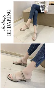 Primer plano de las sandalias de ante beige con tacón de bloque y correas de doble uso