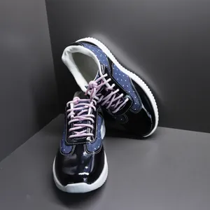 Gedetailleerde weergave van marineblauwe sneakers met stippen, lakleer en veters