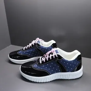 Detail van canvas sneakers met stippen, roze veters en een dikke witte platformzool