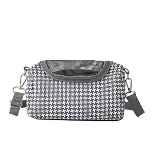 Portable small pet carrier with houndstooth pattern and breathable mesh window.