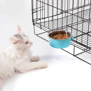 Blauer hängender Futternapf aus Edelstahl am Käfig mit einer Katze davor
