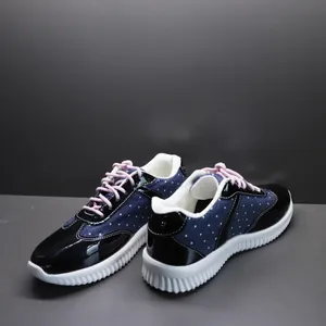 Gedetailleerde weergave van blauwe polkadotsneakers met roze veters en witte zool