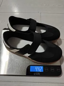 Zapatos Mary Jane negros retro con tira de velcro pesados en una báscula digital