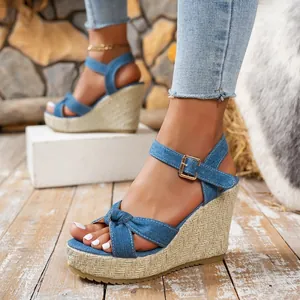 Close-up of stylish denim wedge sandals featuring a braided platform and buckle strap.