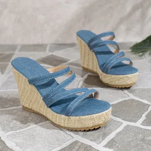 Detailed close-up view of stylish blue denim wedge sandals with braided rope platform soles