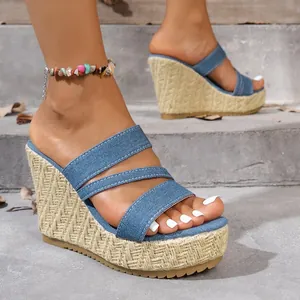 Close-up view of trendy blue denim platform wedge sandals featuring woven soles.
