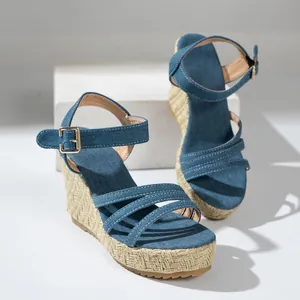 Detailed view of women's blue denim wedge sandals with woven jute platform texture