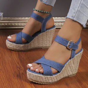 Detailed macro shot of women's denim wedge sandals with woven straw platform heels