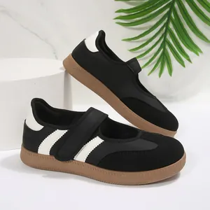 Detalle de zapatos Mary Jane negros retro con rayas blancas y suela de goma flexible