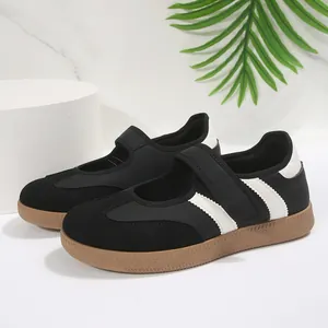 Vista detallada de los zapatos planos Mary Jane negros con rayas blancas dentadas