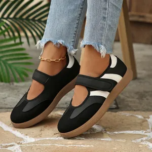 Vista detallada de zapatillas Mary Jane retro en blanco y negro con tiras de velcro al pie.