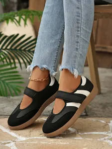 Primer plano de zapatillas Mary Jane retro en blanco y negro con cierre de velcro.