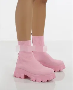 Detailweergave van roze gebreide soklaarzen met een dikke plateauzool en profiel.