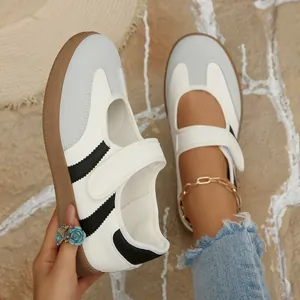Elegantes zapatos Mary Jane retro con correa de velcro y suela plana en blanco.