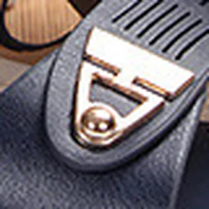 Close-up detail of the iconic metallic H logo ornament on a black wedge sandal strap