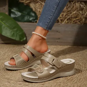 Detailed view of women's beige wedge sandals with decorative cutouts and thick sole