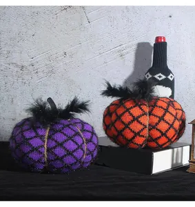 Hand-knitted purple and orange Halloween pumpkins with black net and feather accents.