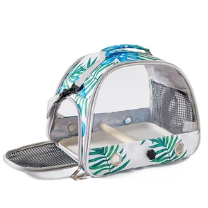 Portable bird carrier with tropical leaf print and internal wooden perch for pet travel.