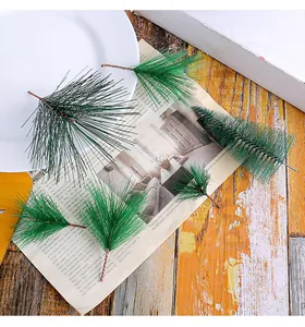Vue détaillée de branches d'aiguilles de pin artificielles et mini sapins sur fond journal
