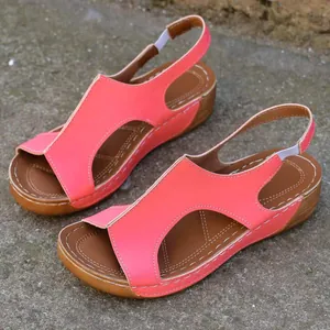 Vue détaillée de sandales compensées rose corail ajourées avec coutures blanches