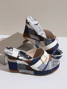 Vue détaillée de mules compensées vintage pour femmes avec imprimé journal et boucle dorée