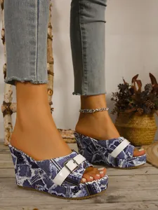 Gros plan sur les sandales compensées vintage à imprimé journal denim et boucle