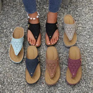 Collection of women's laser-cut wedge flip-flop sandals in multiple colors on gravel.