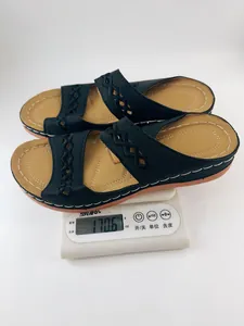 Sandales compensées noires légères pour femmes sur une balance numérique pour le poids