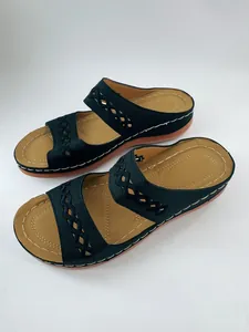 Détail de sandales compensées noires pour femmes avec brides tressées élégantes.