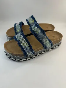 Detail von Damen-Plateau-Sandalen mit strassbesetzten Denim-Fransenriemen.