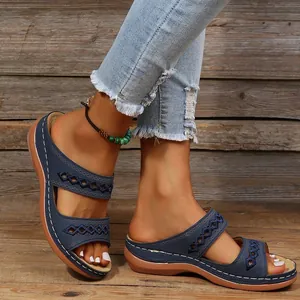 Détails de mules à talons compensés bleues avec motifs ajourés et semelle épaisse.